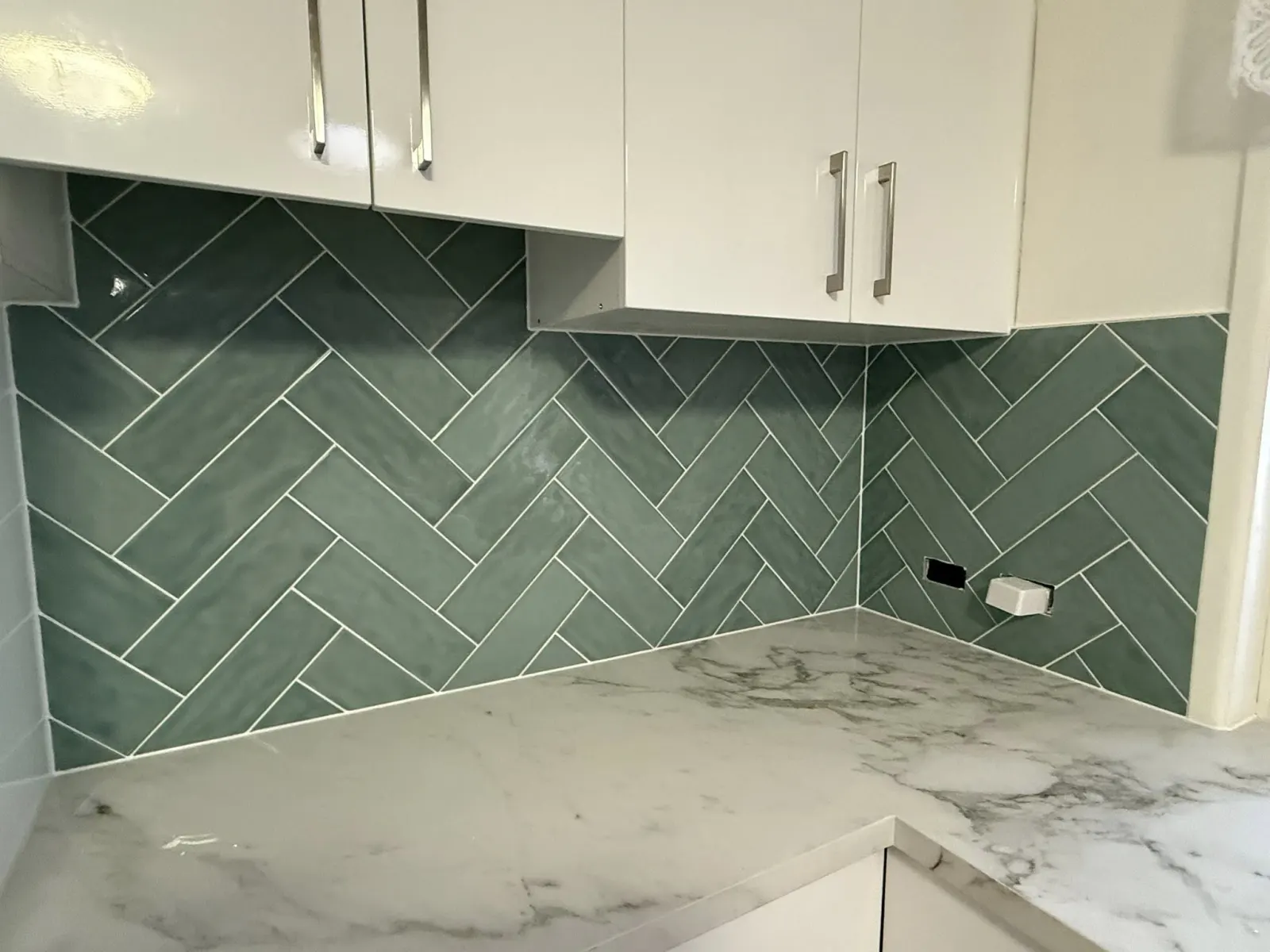 Green herringbone kitchen splashback tiled by Set Right Tiling in Brisbane