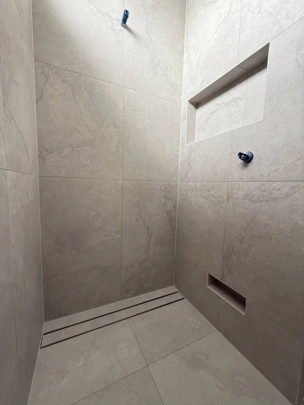 Large-format tiled bathroom wall with shower niche in Brisbane